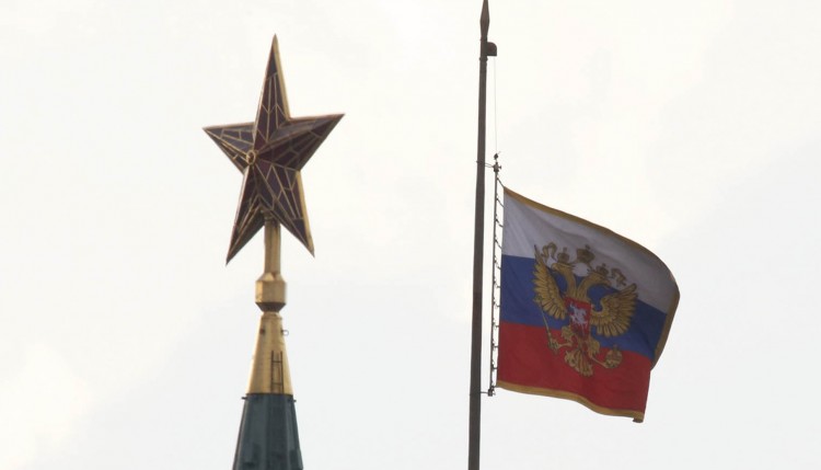 A Russian national flag flutters in half mast near a star on the top of a Kremlin tower as Moscow holds mourning for the victims of victims of Tuesday's metro accident in Moscow