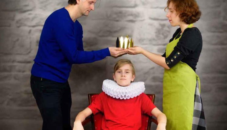 Parents put a crown on the head of their son. Permissive (indulg